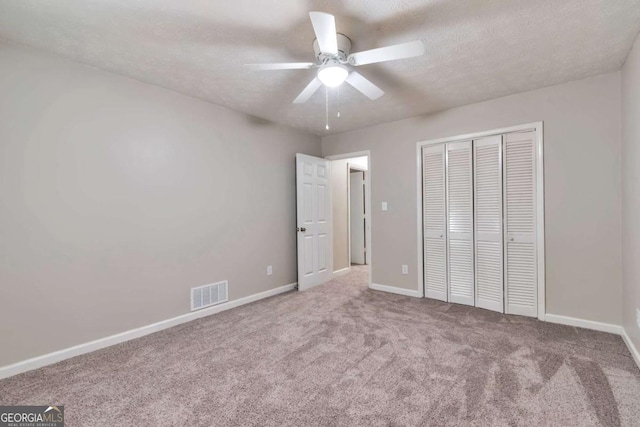 5215 Mainstreet Park Dr, Stone Mountain, GA 30088 - unfurnished bedroom with carpet floors, a closet, a ceiling fan, and a textured ceiling