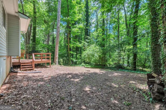 5215 Mainstreet Park Dr, Stone Mountain, GA 30088 - view of yard featuring a wooden deck and a forest view