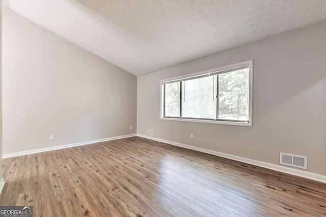 5215 Mainstreet Park Dr, Stone Mountain, GA 30088 - spare room featuring wood finished floors and vaulted ceiling