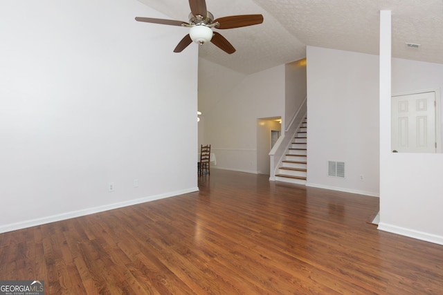 552 Caseys Xing, Winder, GA 30680 - unfurnished living room featuring ceiling fan, wood finished floors, stairway, and vaulted ceiling