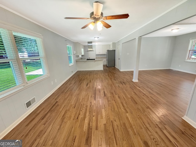 314 Pine St, Barnesville, GA 30204 - unfurnished living room with a ceiling fan, light wood-style flooring, and crown molding