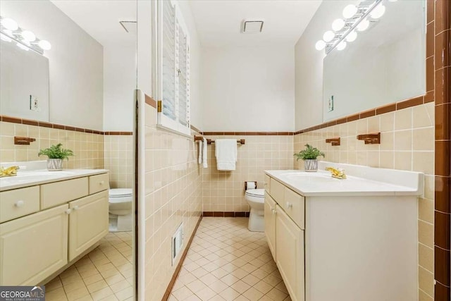 5114 N Ivy Rd NE, Atlanta, GA 30342 - full bathroom featuring tile walls, vanity, tile patterned floors, and wainscoting