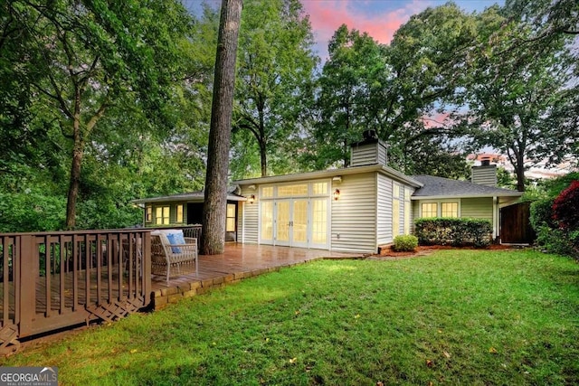 5114 N Ivy Rd NE, Atlanta, GA 30342 - rear view of house with a chimney, a deck, a lawn, and french doors