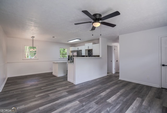 3570 Briar Dr, Lithia Springs, GA 30122 - unfurnished living room featuring dark wood finished floors, a ceiling fan, and a textured ceiling