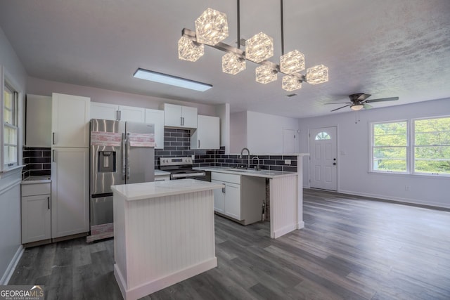 3570 Briar Dr, Lithia Springs, GA 30122 - kitchen with stainless steel appliances, a peninsula, decorative backsplash, dark wood-style floors, and light countertops