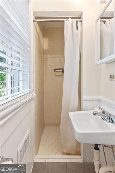 348 7th St NE, Atlanta, GA 30308 - full bath featuring a tile shower, wainscoting, and tile patterned flooring