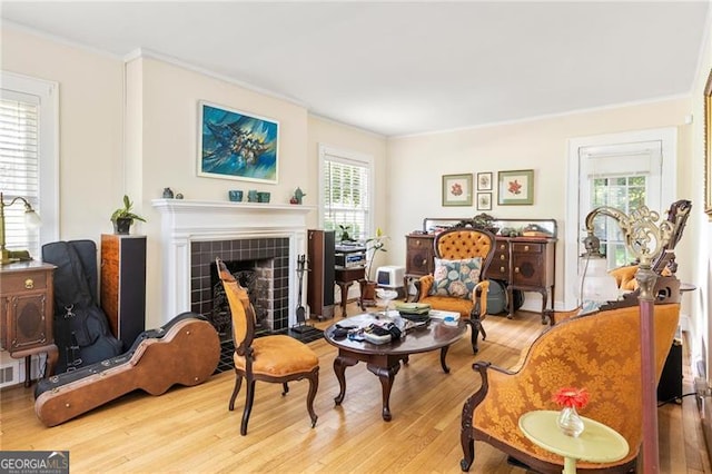 348 7th St NE, Atlanta, GA 30308 - living area with wood finished floors, ornamental molding, healthy amount of natural light, and a tiled fireplace