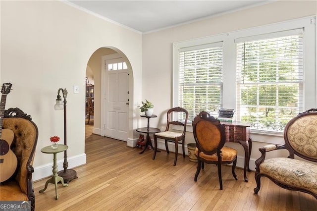 348 7th St NE, Atlanta, GA 30308 - living area featuring light wood-style floors, arched walkways, crown molding, and plenty of natural light