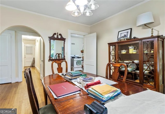 348 7th St NE, Atlanta, GA 30308 - dining space with a chandelier, arched walkways, light wood-style floors, and ornamental molding