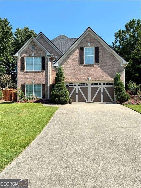 3560 Elinburg Dr, Buford, GA 30519 - traditional-style home with driveway, a garage, brick siding, and a front lawn