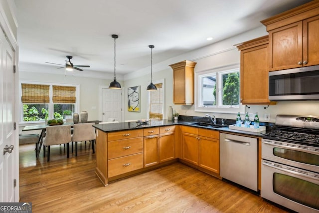 261 Elmira Pl NE, Atlanta, GA 30307 - kitchen featuring stainless steel appliances, a peninsula, ceiling fan, brown cabinets, and light wood finished floors