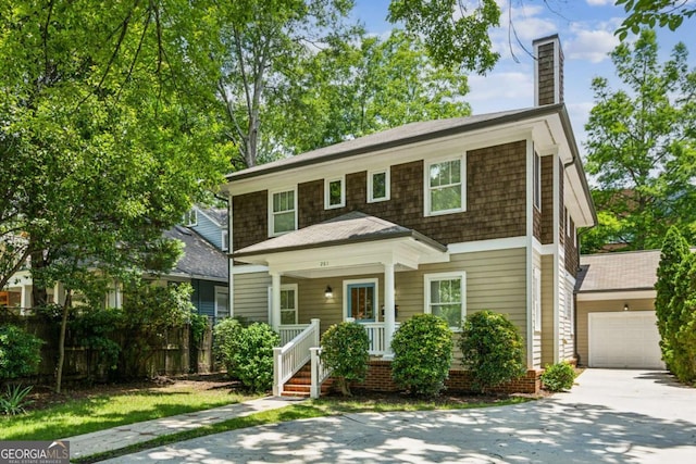 261 Elmira Pl NE, Atlanta, GA 30307 - view of front facade featuring a porch, concrete driveway, a chimney, and a garage