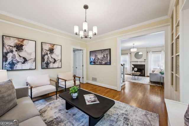 261 Elmira Pl NE, Atlanta, GA 30307 - living room with a chandelier, wood finished floors, crown molding, and a fireplace