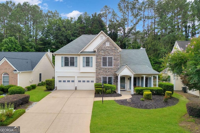 4206 Moccasin Trl, Woodstock, GA 30189 - view of front of home featuring stone siding, an attached garage, a front lawn, driveway, and covered porch