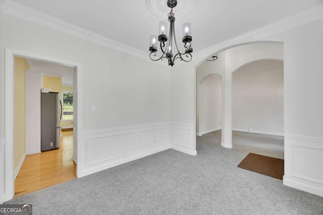 4206 Moccasin Trl, Woodstock, GA 30189 - carpeted spare room featuring arched walkways, a chandelier, ornamental molding, and a wainscoted wall