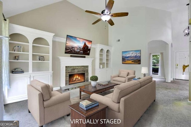 4206 Moccasin Trl, Woodstock, GA 30189 - living area with high vaulted ceiling, carpet, a ceiling fan, a stone fireplace, and arched walkways