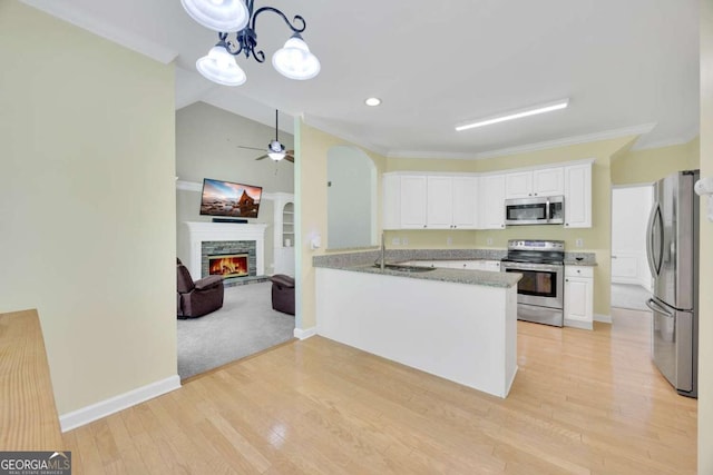 4206 Moccasin Trl, Woodstock, GA 30189 - kitchen featuring stainless steel appliances, white cabinetry, open floor plan, ceiling fan, and ornamental molding