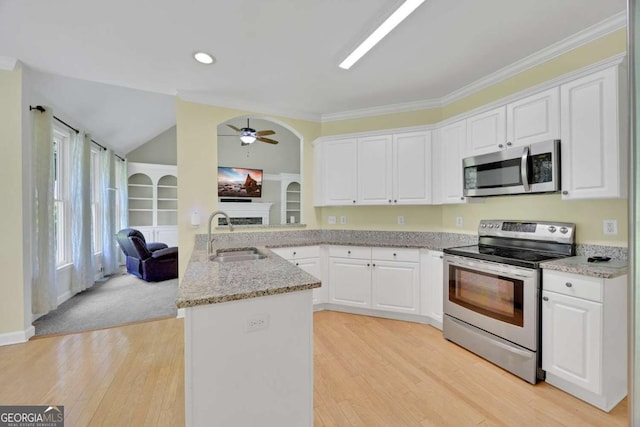 4206 Moccasin Trl, Woodstock, GA 30189 - kitchen featuring stainless steel appliances, a peninsula, a fireplace, white cabinetry, and crown molding