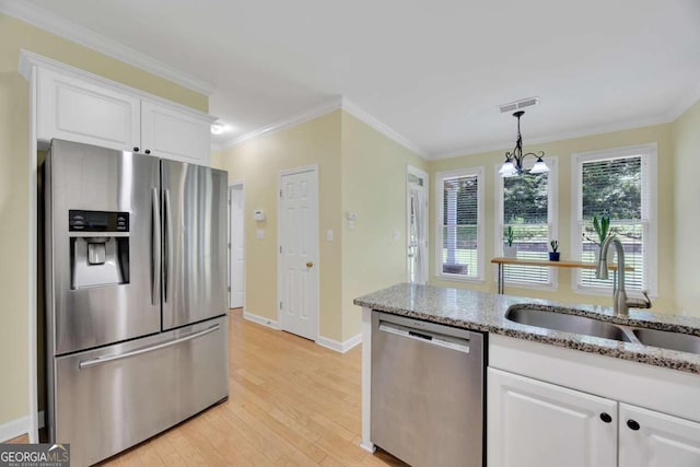 4206 Moccasin Trl, Woodstock, GA 30189 - kitchen with stainless steel appliances, light wood-style floors, white cabinetry, light stone counters, and ornamental molding