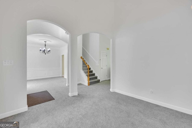 4206 Moccasin Trl, Woodstock, GA 30189 - carpeted spare room featuring stairway, arched walkways, ornamental molding, and a chandelier
