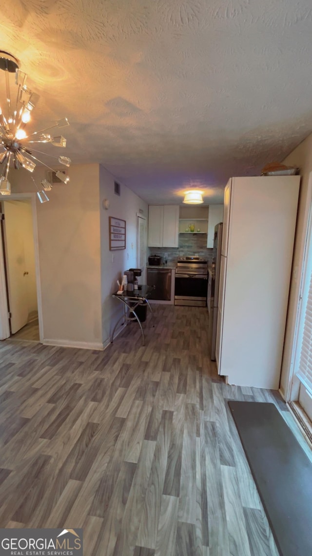 501 Carlton Rd # 3B, Palmetto, GA 30268 - kitchen with stainless steel electric stove, wood finished floors, white cabinetry, a chandelier, and a textured ceiling