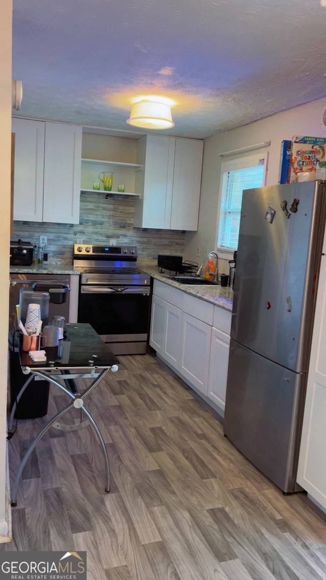 501 Carlton Rd # 3B, Palmetto, GA 30268 - kitchen with appliances with stainless steel finishes, white cabinets, decorative backsplash, open shelves, and wood finished floors