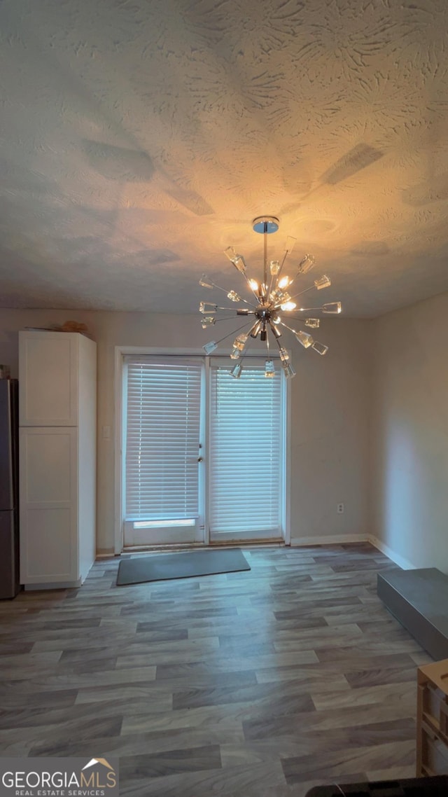 501 Carlton Rd # 3B, Palmetto, GA 30268 - empty room featuring a chandelier, a textured ceiling, and wood finished floors