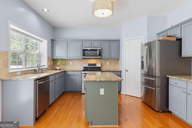 5003 Pacific Dunes Dr, Suwanee, GA 30024 - kitchen with stainless steel appliances, gray cabinetry, a kitchen island, tasteful backsplash, and recessed lighting