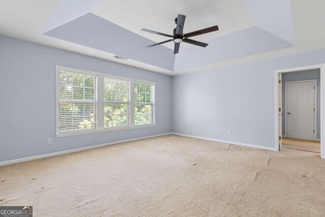 5003 Pacific Dunes Dr, Suwanee, GA 30024 - empty room featuring a tray ceiling, carpet, and ceiling fan