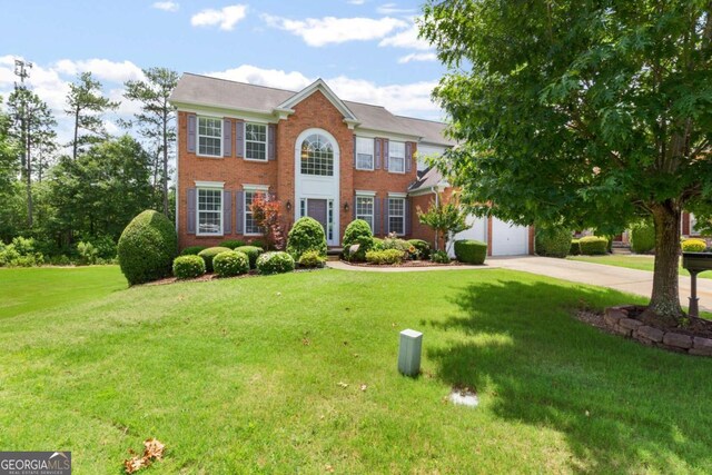 5003 Pacific Dunes Dr, Suwanee, GA 30024 - colonial-style house featuring driveway, a front yard, brick siding, and an attached garage