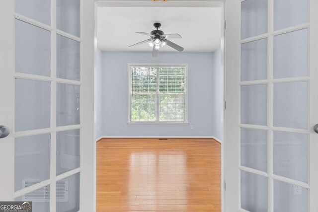 5003 Pacific Dunes Dr, Suwanee, GA 30024 - spare room with wood finished floors, ceiling fan, and french doors