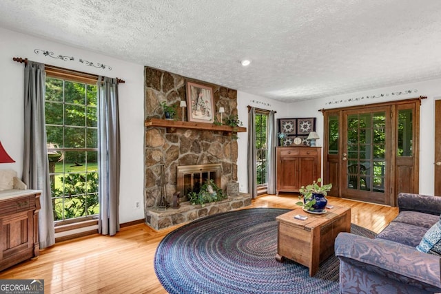 3754 Wyntuck Cir NW, Kennesaw, GA 30152 - living room featuring a textured ceiling, light wood-type flooring, and a fireplace