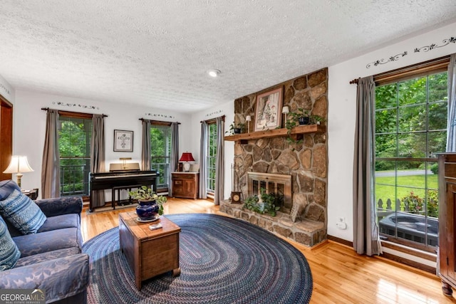 3754 Wyntuck Cir NW, Kennesaw, GA 30152 - living room featuring a textured ceiling, light wood-style flooring, and a fireplace