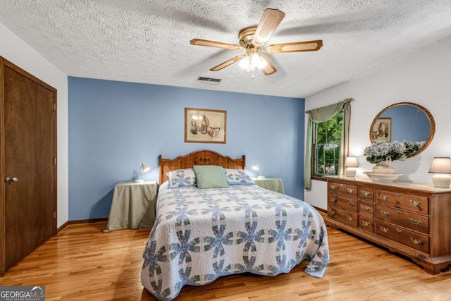 3754 Wyntuck Cir NW, Kennesaw, GA 30152 - bedroom featuring light wood-style floors, a textured ceiling, a ceiling fan, and a closet