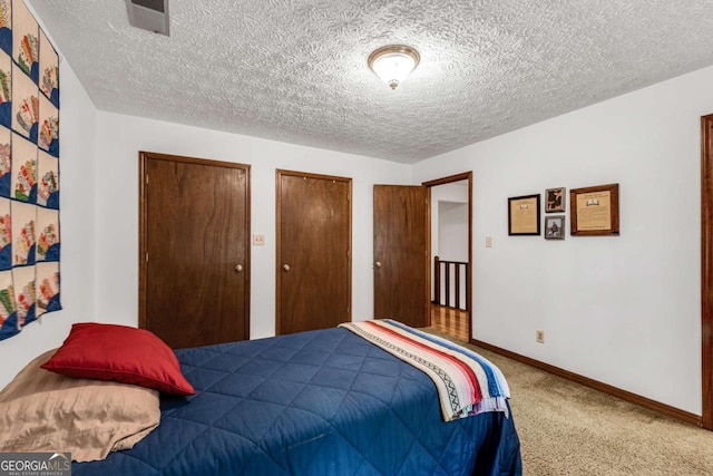 3754 Wyntuck Cir NW, Kennesaw, GA 30152 - bedroom featuring a textured ceiling, carpet, and two closets
