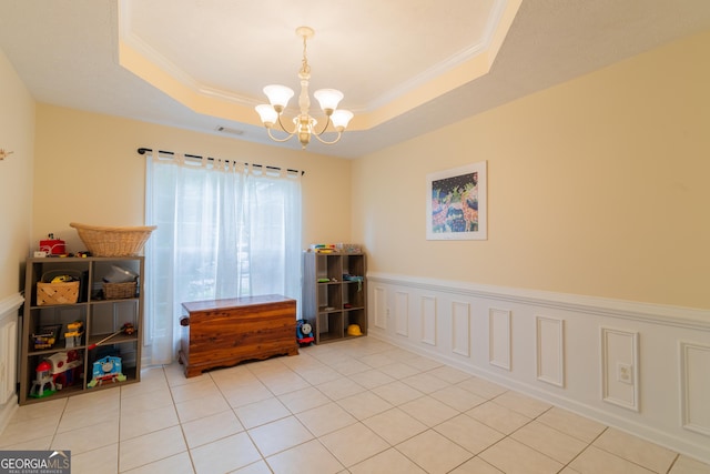 3030 Thornberry Cir, Phenix City, AL 36867 - spare room with a chandelier, a tray ceiling, light tile patterned floors, a wainscoted wall, and crown molding