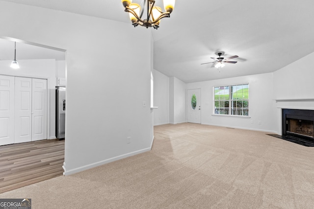 165 Lost Lake Trl, Villa Rica, GA 30180 - unfurnished living room with light carpet, a chandelier, a ceiling fan, a fireplace with flush hearth, and vaulted ceiling