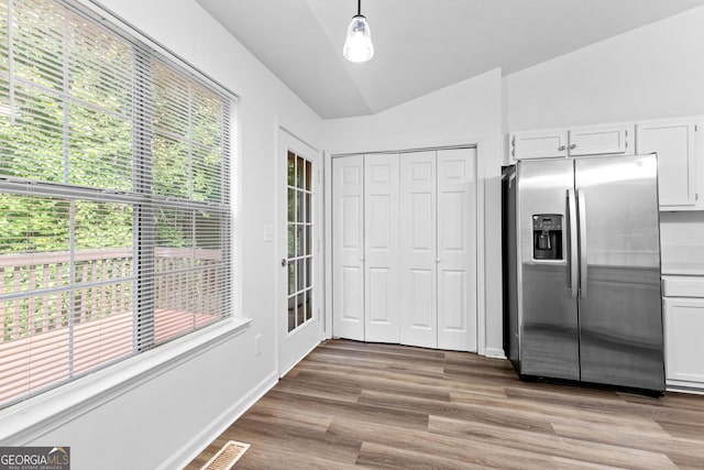 165 Lost Lake Trl, Villa Rica, GA 30180 - kitchen with stainless steel fridge, white cabinetry, wood finished floors, decorative light fixtures, and lofted ceiling