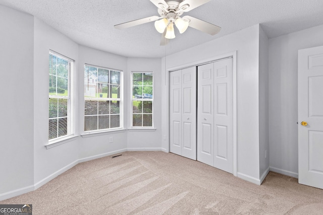 165 Lost Lake Trl, Villa Rica, GA 30180 - unfurnished bedroom featuring carpet flooring, a textured ceiling, a closet, and a ceiling fan