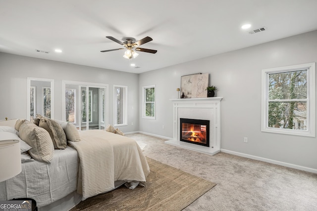55 Summerhill Pl, Newnan, GA 30263 - bedroom featuring multiple windows, a glass covered fireplace, recessed lighting, light carpet, and ceiling fan