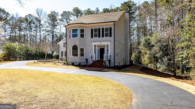 55 Summerhill Pl, Newnan, GA 30263 - view of front of home with curved driveway, a front yard, a chimney, and stucco siding