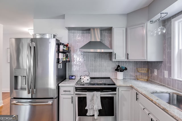 7250 Hunters Branch Dr, Atlanta, GA 30328 - kitchen featuring appliances with stainless steel finishes, wall chimney range hood, decorative backsplash, and light stone countertops
