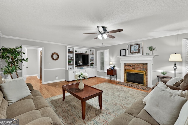 1505 Misty Valley Dr, Chatsworth, GA 30705 - living room with a ceiling fan, light wood-type flooring, a textured ceiling, crown molding, and a brick fireplace
