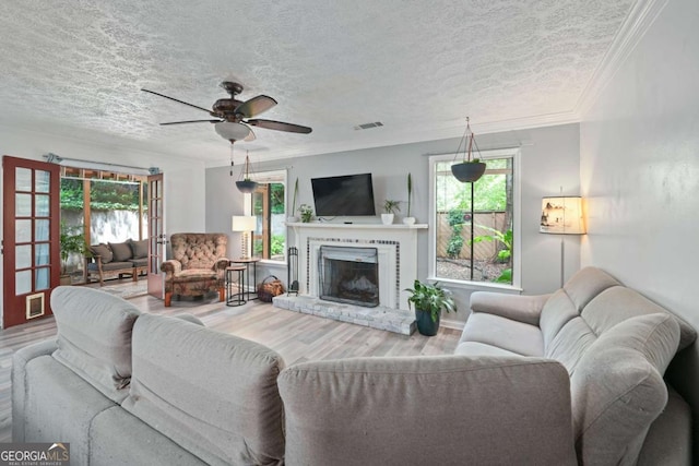 834 Lake Hollow Blvd SW, Marietta, GA 30064 - living room with wood finished floors, a textured ceiling, plenty of natural light, ceiling fan, and a fireplace