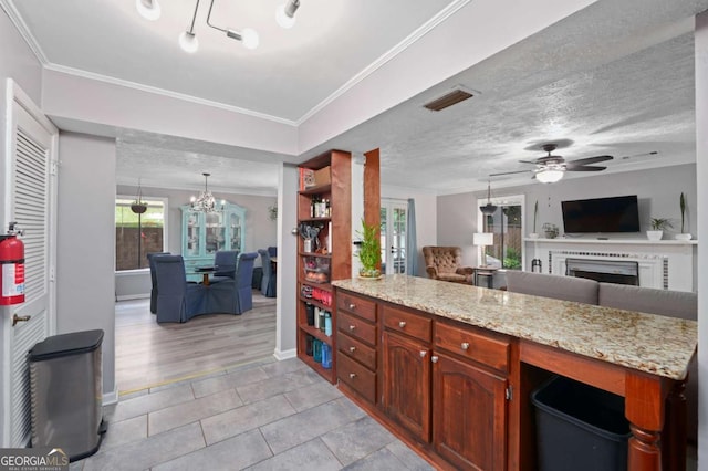 834 Lake Hollow Blvd SW, Marietta, GA 30064 - kitchen featuring a fireplace, open floor plan, ceiling fan, a chandelier, and light tile patterned floors