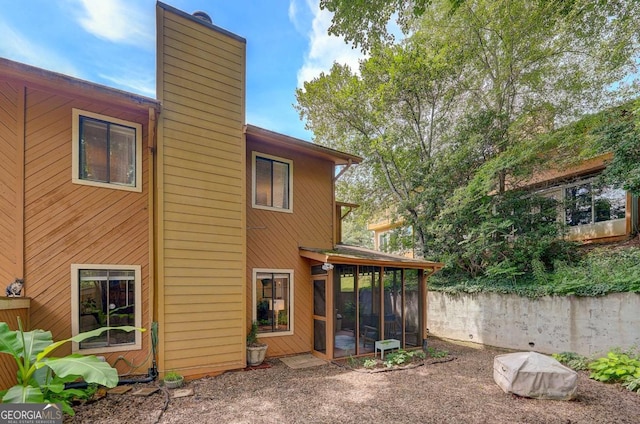 834 Lake Hollow Blvd SW, Marietta, GA 30064 - rear view of house with a chimney and a sunroom