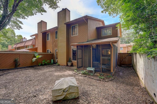 834 Lake Hollow Blvd SW, Marietta, GA 30064 - rear view of house with a sunroom, a fenced backyard, and a chimney