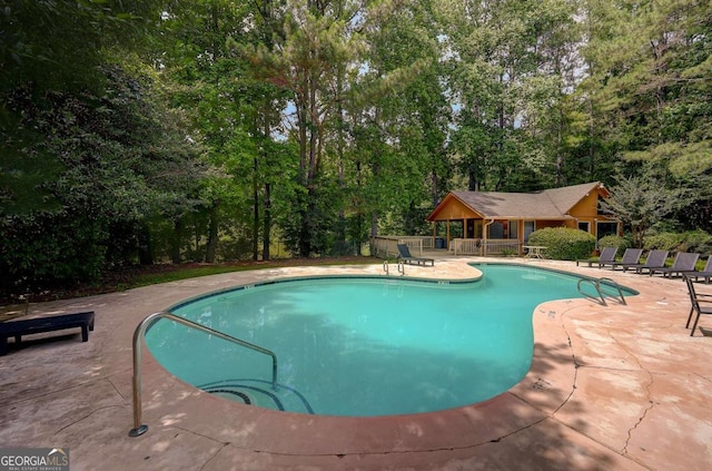 834 Lake Hollow Blvd SW, Marietta, GA 30064 - outdoor pool featuring a patio area and view of wooded area