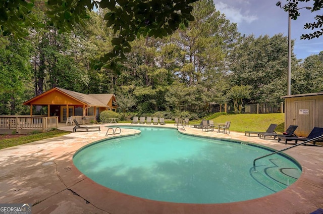 834 Lake Hollow Blvd SW, Marietta, GA 30064 - community pool featuring a patio, an outbuilding, view of wooded area, and a wooden deck