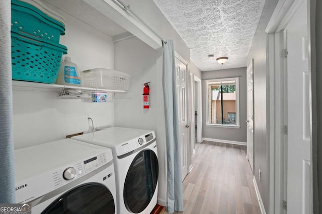 834 Lake Hollow Blvd SW, Marietta, GA 30064 - laundry room featuring washer and clothes dryer, light wood finished floors, and a textured ceiling